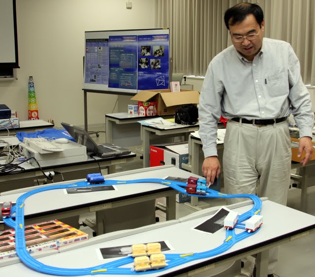 Prof. Wada uses trains in a variation of the orange game, Informatics Education Symposium 2010, Osaka, Japan